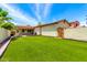Expansive backyard featuring lush green turf, a patio, and privacy walls at 3819 N Springfield St, Buckeye, AZ 85396