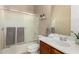Well-lit bathroom features a shower-tub combination with sliding glass doors and a vanity with a white sink at 3819 N Springfield St, Buckeye, AZ 85396