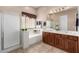 Well-lit bathroom boasting double sinks, soaking tub, glass shower, and earthy tile flooring, offering a spa-like ambiance at 3819 N Springfield St, Buckeye, AZ 85396