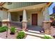 Close-up view of the covered front porch, showcasing brick pillars and manicured landscaping at 3819 N Springfield St, Buckeye, AZ 85396