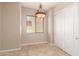 Bright dining area with tile flooring, a modern light fixture, and a view to the outside at 3819 N Springfield St, Buckeye, AZ 85396