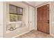 Cozy entryway featuring a window seat, neutral tones, and a solid wood door at 3819 N Springfield St, Buckeye, AZ 85396