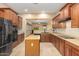 Well-equipped kitchen showcasing stainless steel appliances, an island, and warm wood cabinetry at 3819 N Springfield St, Buckeye, AZ 85396