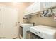 A practical laundry room with ample storage, washer, dryer, and utility sink at 3819 N Springfield St, Buckeye, AZ 85396