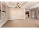 Open-concept living area featuring plush carpeting, a chandelier, and abundant natural light at 3819 N Springfield St, Buckeye, AZ 85396