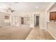 Bright, carpeted living room adjoining kitchen, separated by countertop, offering an open floor plan at 3819 N Springfield St, Buckeye, AZ 85396