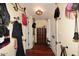 Hallway featuring dark wood floors, hooks on the walls, and three doors leading to various rooms at 4317 N 70Th St, Scottsdale, AZ 85251