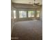 Spacious carpeted living room with a ceiling fan and multiple windows providing ample natural light at 4581 E Apricot Ln, Gilbert, AZ 85298