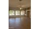 Bright living room with tile floors, large windows offering backyard views, and a ceiling fan at 4581 E Apricot Ln, Gilbert, AZ 85298