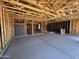 A spacious garage showing unfinished drywall and wooden framing, awaiting customization to suit the homeowner's needs and preferences at 46850 W Old Timer Rd, Maricopa, AZ 85139