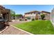 Manicured backyard with a pool, green artificial turf, and gravel landscaping for easy maintenance at 5110 E Mark Ln, Cave Creek, AZ 85331