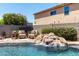 Beautiful pool with waterfall feature, patio furniture, and desert landscaping create backyard paradise at 5110 E Mark Ln, Cave Creek, AZ 85331