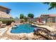 Backyard featuring a private pool with a rock waterfall feature and lounge chairs for relaxing at 5110 E Mark Ln, Cave Creek, AZ 85331