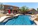 Sparkling pool with lounge chairs and umbrella, complemented by lush landscaping, creates relaxing backyard oasis at 5110 E Mark Ln, Cave Creek, AZ 85331