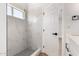 Bathroom featuring a marble tile shower, hexagon floor tile, and a glass window at 5125 W Wickiup Ln, Glendale, AZ 85308