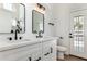 Bathroom featuring double sinks, quartz countertops, black fixtures, and a tiled shower at 5125 W Wickiup Ln, Glendale, AZ 85308