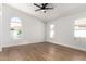 Bright bedroom with wood floors, a ceiling fan, and arched windows with beautiful outside views at 5125 W Wickiup Ln, Glendale, AZ 85308