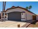 Garage exterior featuring a terracotta roof, a concrete driveway, and desert landscaping at 5125 W Wickiup Ln, Glendale, AZ 85308