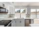 Modern kitchen featuring white cabinetry, chevron backsplash, stainless steel appliances and a large window at 5125 W Wickiup Ln, Glendale, AZ 85308