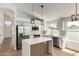 Modern kitchen featuring stainless steel appliances, a central island, and bright cabinets at 5125 W Wickiup Ln, Glendale, AZ 85308