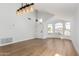 Spacious living room featuring vaulted ceilings, wood floors, arched windows and a modern light fixture at 5125 W Wickiup Ln, Glendale, AZ 85308