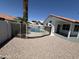 Backyard pool with rock landscaping, safety fence, and view of house at 5125 W Wickiup Ln, Glendale, AZ 85308
