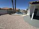 Backyard pool with decorative rock landscaping, safety fence, and proximity to house at 5125 W Wickiup Ln, Glendale, AZ 85308