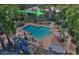 This aerial view highlights a community pool area with chairs, lush landscaping, and spa at 5203 N 24Th St # 207, Phoenix, AZ 85016