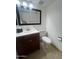 Well-maintained bathroom featuring a dark wood vanity, white sink, toilet and black-framed mirror at 5203 N 24Th St # 207, Phoenix, AZ 85016