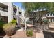An exterior courtyard featuring a charming fountain, lush greenery, and stairs to upper units at 5203 N 24Th St # 207, Phoenix, AZ 85016