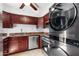 Modern kitchen featuring stainless steel appliances, dark wood cabinets, and a stackable washer/dryer unit at 5203 N 24Th St # 207, Phoenix, AZ 85016