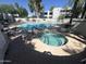 Community pool and hot tub surrounded by lounge chairs, beautiful landscaping, and shade trees at 5203 N 24Th St # 207, Phoenix, AZ 85016