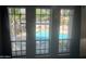 View of the community pool area from inside through three pane windows with black frames and draperies at 5203 N 24Th St # 207, Phoenix, AZ 85016