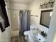 Well-lit bathroom featuring a shower-tub, decorative mirror and granite countertop at 5529 W Zoe Ella Way, Glendale, AZ 85306