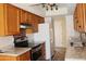 Well-lit kitchen with modern appliances, granite countertops, wood cabinets, and tile flooring at 5529 W Zoe Ella Way, Glendale, AZ 85306