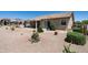 Beautiful desert landscaped backyard with a covered patio, a built-in barbecue, and lush desert plants at 6080 S Jojoba Ct, Gold Canyon, AZ 85118