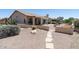 Expansive backyard with desert landscaping, a covered patio, and beautiful stone walkways at 6080 S Jojoba Ct, Gold Canyon, AZ 85118