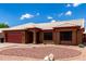 Charming single-story home featuring a red garage door, beautiful desert landscaping, and a white tiled roof at 6302 E Portia St, Mesa, AZ 85215