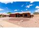 Charming single-story home featuring a red garage door, beautiful desert landscaping, and a white tiled roof at 6302 E Portia St, Mesa, AZ 85215