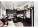 Contemporary kitchen boasts stylish black cabinets, neutral backsplash, and modern appliances at 6302 E Portia St, Mesa, AZ 85215