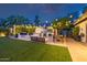 Resort-style backyard with outdoor kitchen, fireplace, seating area, and lush landscaping at 7821 N Via De La Sombre --, Scottsdale, AZ 85258