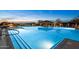 A beautiful community pool is lit up at night with a covered lounge area at 8633 E Kael Cir, Mesa, AZ 85207