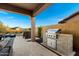 The outdoor kitchen features a built-in grill and dining space near the pool and covered patio at 8633 E Kael Cir, Mesa, AZ 85207