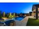Inviting backyard pool with a spa and a covered patio is beautifully lit at night at 8633 E Kael Cir, Mesa, AZ 85207
