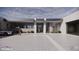 Modern home exterior featuring a three-car garage, a stylish car, and a tiled driveway leading to the entrance at 9002 E Havasupai Dr, Scottsdale, AZ 85255
