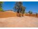Expansive backyard with minimal grass, featuring a swing set and orange brick wall at 948 E Wiley Way, Casa Grande, AZ 85122