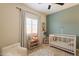 Bright Bedroom featuring a crib, chair, window and decorative shelving at 948 E Wiley Way, Casa Grande, AZ 85122
