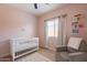 Charming Bedroom with a crib, comfortable glider, window, and decorative bookshelf at 948 E Wiley Way, Casa Grande, AZ 85122