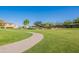 Well-kept community park with a concrete walking trail, playground, and single-Gathering homes at 948 E Wiley Way, Casa Grande, AZ 85122