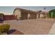 Side view of the property showing brick driveway, three car garage and desert landscaping at 1036 W Siebold Tree Ave, Queen Creek, AZ 85140